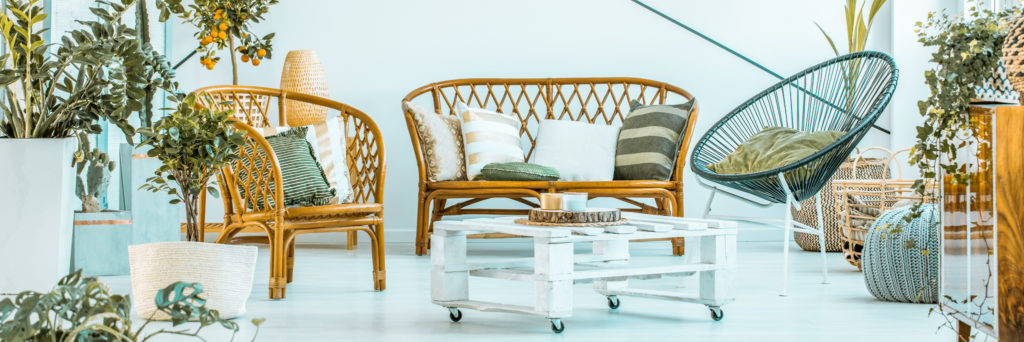 Wohnzimmer Ferienwohnung mit Korbmöbeln und weißem Tisch