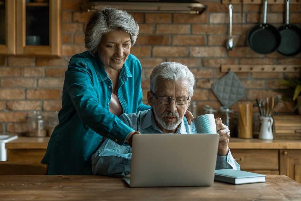 Ferienwohnung vermeiten, älteres Paar bei der Buchung vor dem Laptop