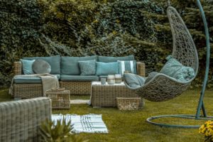 Gartenbereich der Ferienwohnung mit Korbmöbeln und Hängesessel
