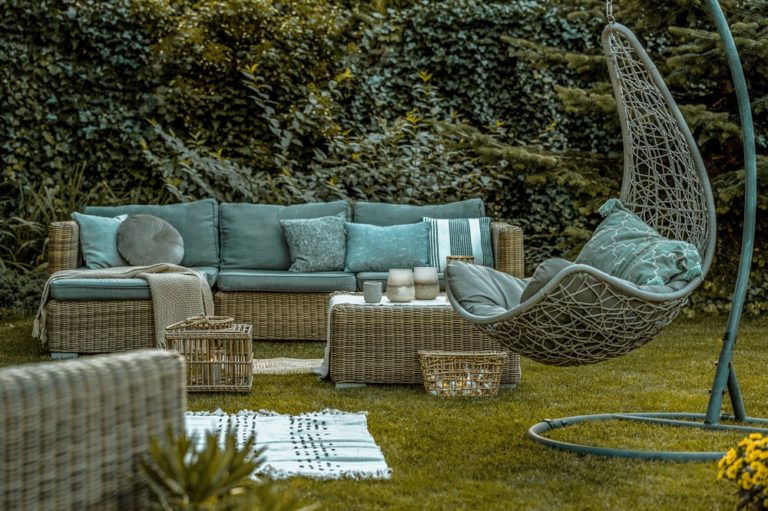 Gartenbereich der Ferienwohnung mit Korbmöbeln und Hängesessel