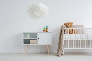 Kinderzimmer einer Ferienwohnung minimalistisch mit Krippe und Komode
